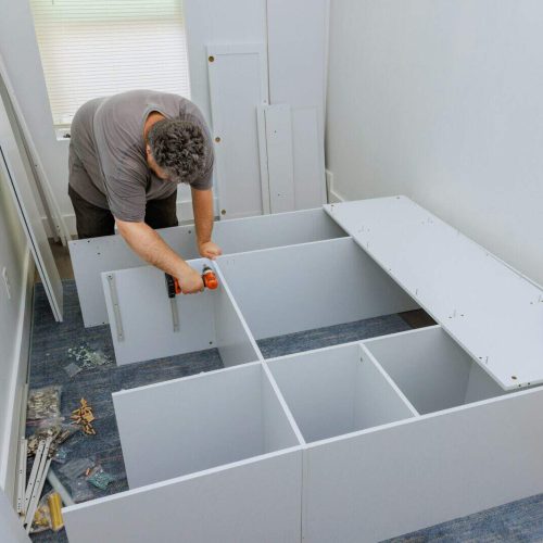 A carpenter was in the process of assembling the wardrobe cabinet that needed to be installed