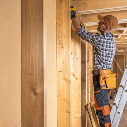 House Construction Supervisor Checking on Wooden Beam