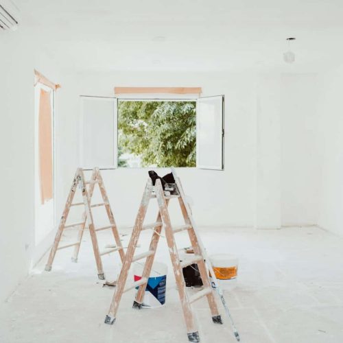 ladders and painter tools on white room at construction site. Painting walls.Home improvement