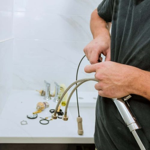 Work in a bathroom plumber holding a faucet plumbing assemble repair service